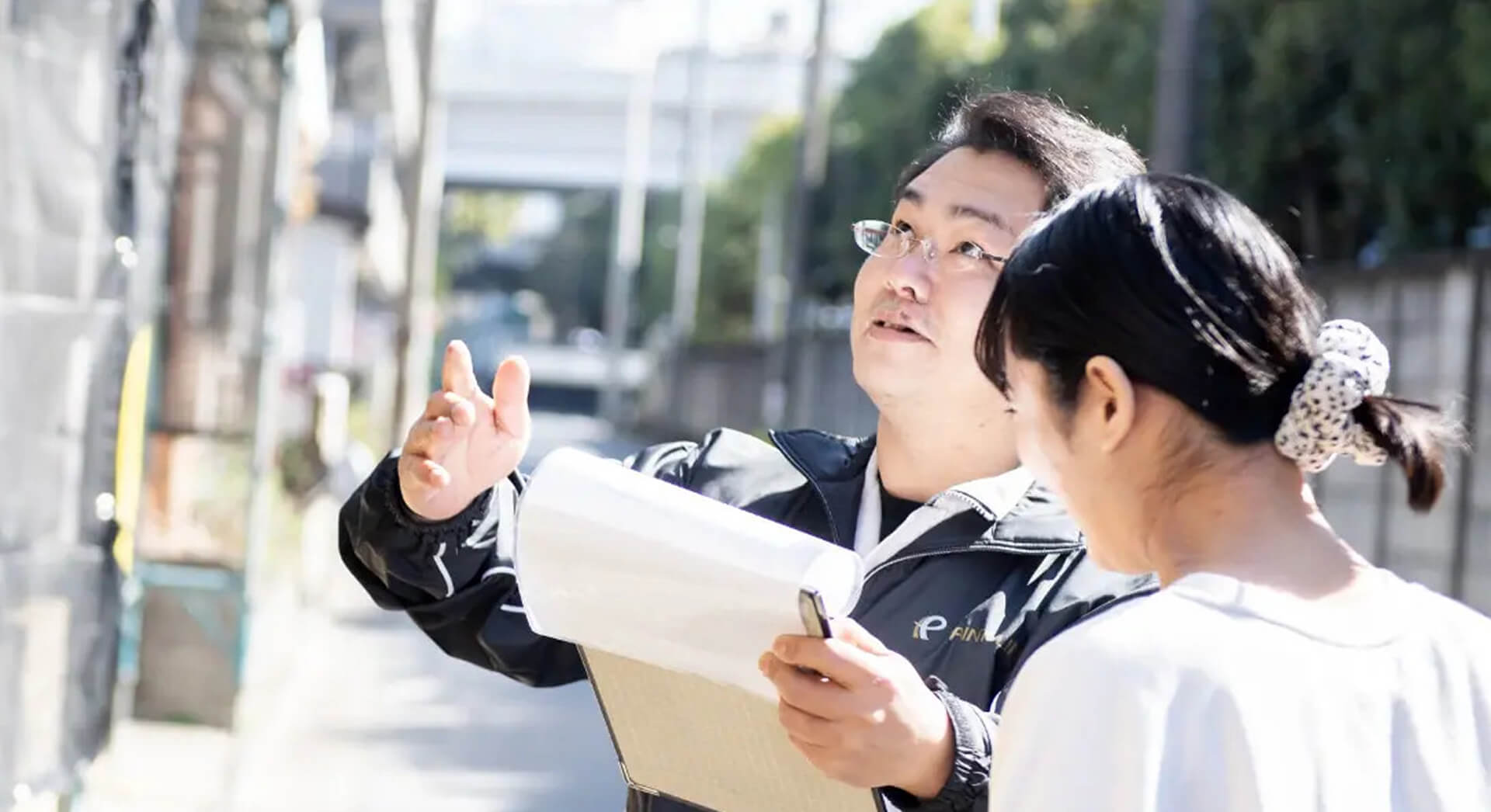 お客様に塗装プランを説明する人の写真